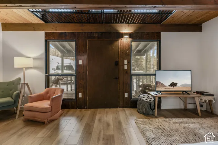 Wood-finish flooring, exposed wood beams, wood wall paneling, and two transom windows