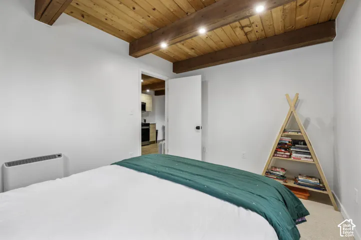 Wood-plank ceiling with exposed beams and recessed lighting