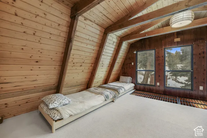 Vaulted wood plank ceilings, exposed wood beams, and a woven pendant light fixture