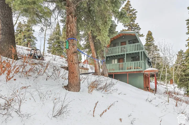 A-frame exterior with two levels of covered balconies, surrounded by mature trees