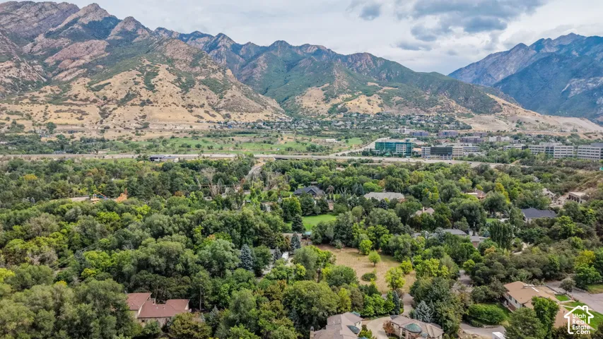 Aerial perspective showcasing mountainous terrain, surrounding natural landscape, and residential properties