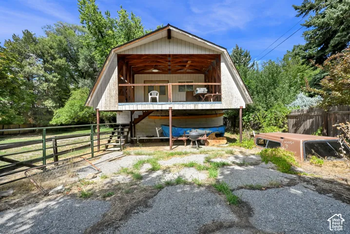 Barn-style structure with an upper-level open balcony and exposed wood beam ceiling