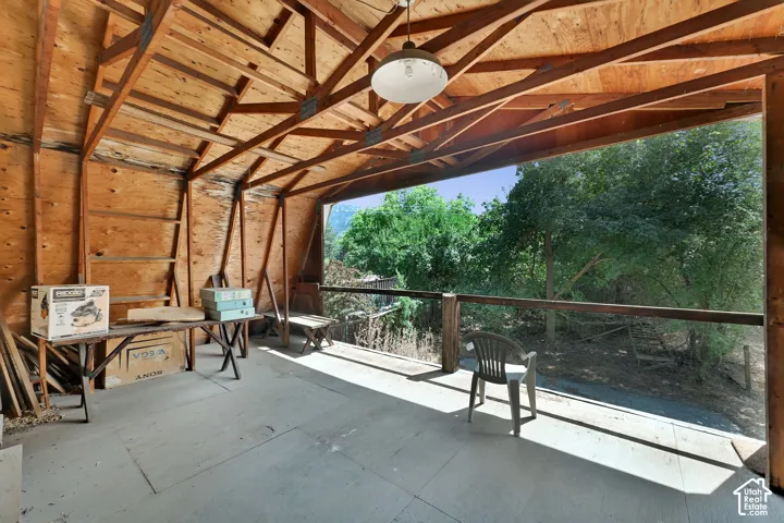Open-air structure with exposed wood framing, wood paneling, and an overhead light fixture