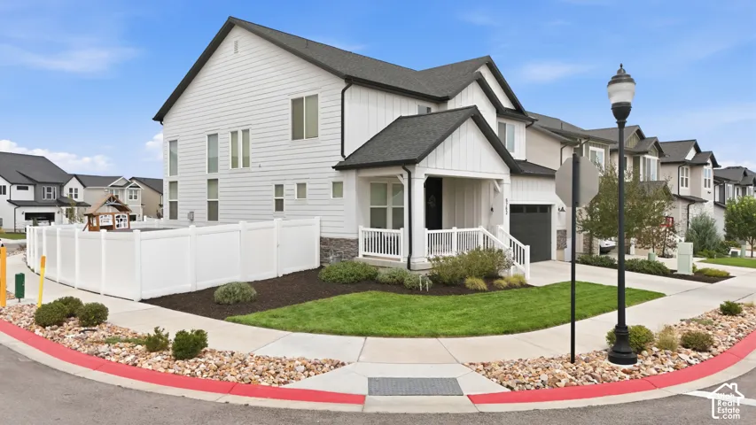 Contemporary exterior with white siding, dark roof, and a covered porch