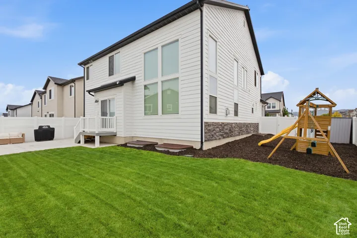Expansive green lawn with a white privacy fence