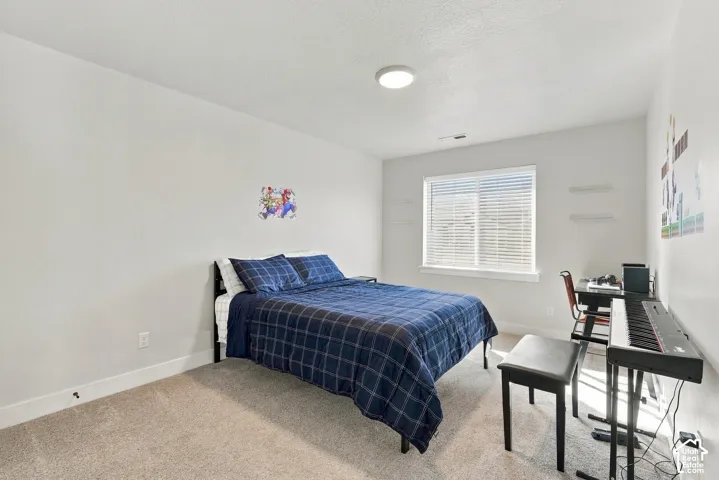 Carpeted room featuring a single window, white walls, and a ceiling-mounted light fixture