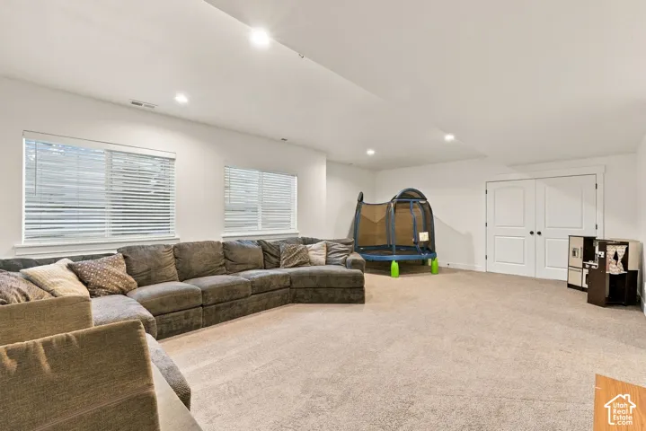 Recessed lighting, carpeted flooring, double windows, white trim, and double panel doors