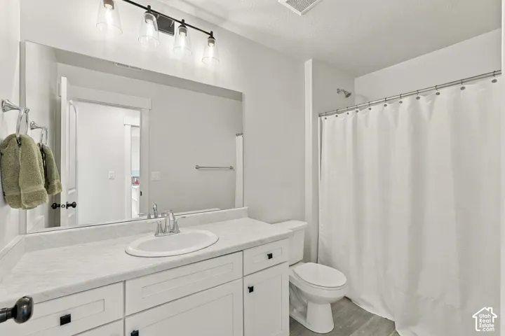 White vanity with black hardware, integrated sink, and light-toned countertop