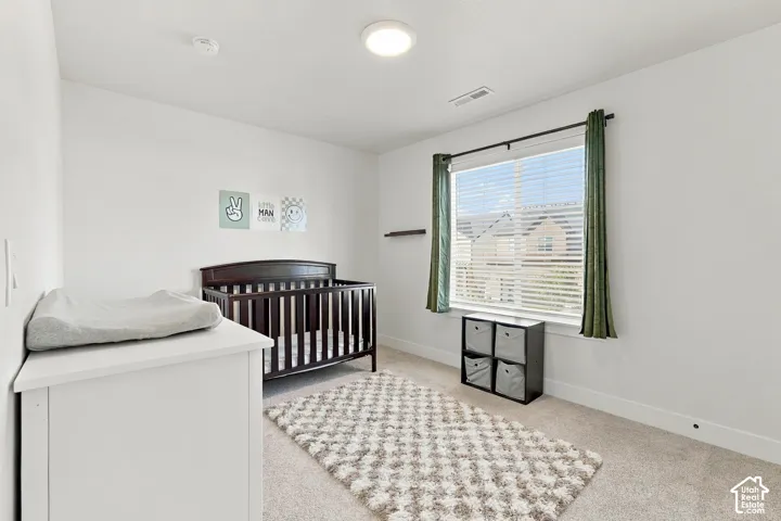 Bright white walls, light-toned carpet, and a large window with blinds