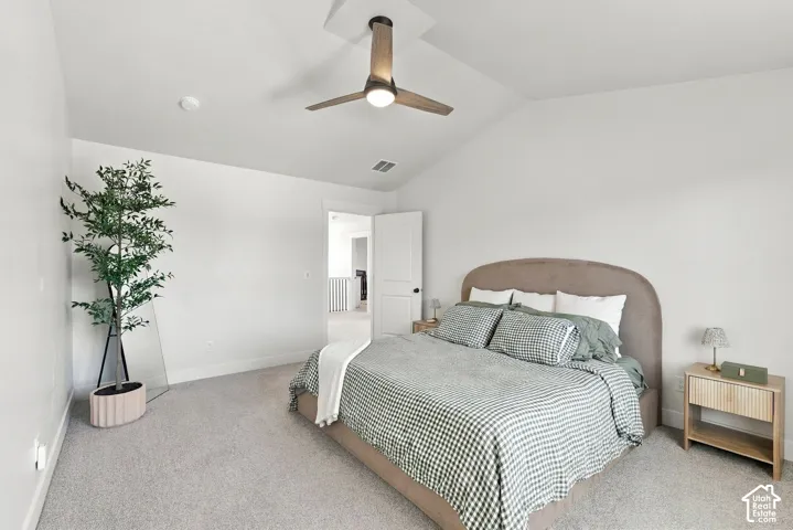 Vaulted ceiling with a wood-finish ceiling fan, recessed lighting, and light-toned carpeting