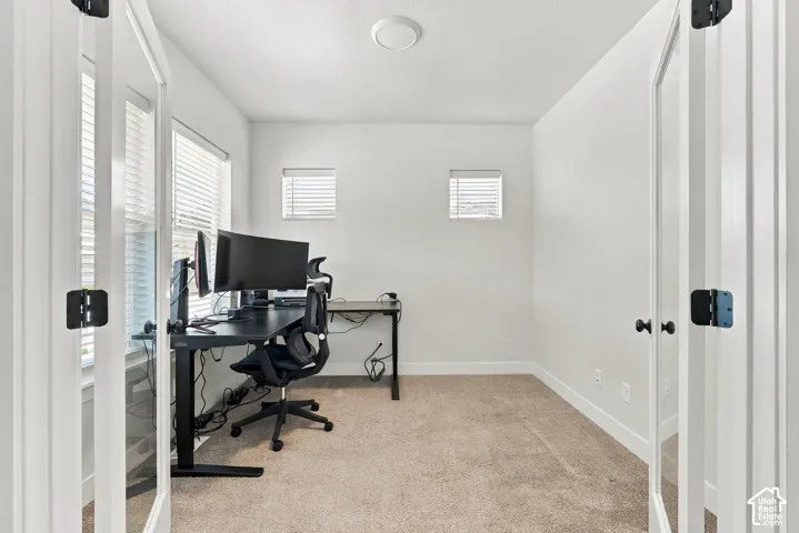 Room featuring carpet flooring, two windows with blinds, and white walls