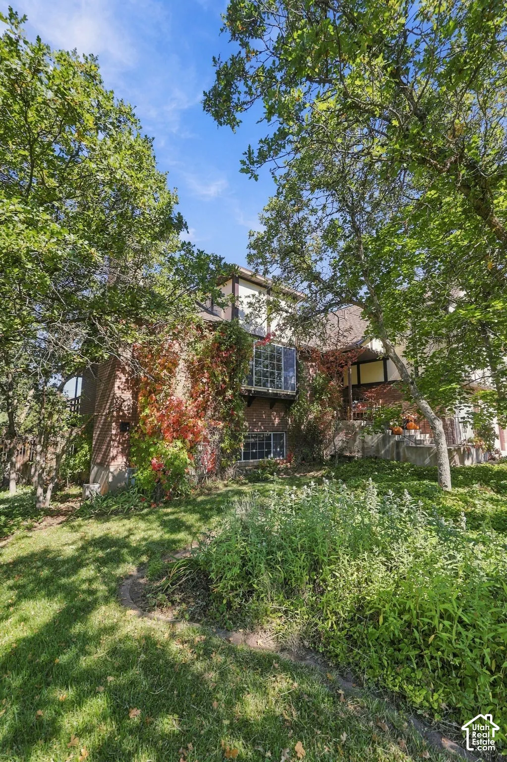Brick exterior with a glass block window feature, and mature trees providing natural shade