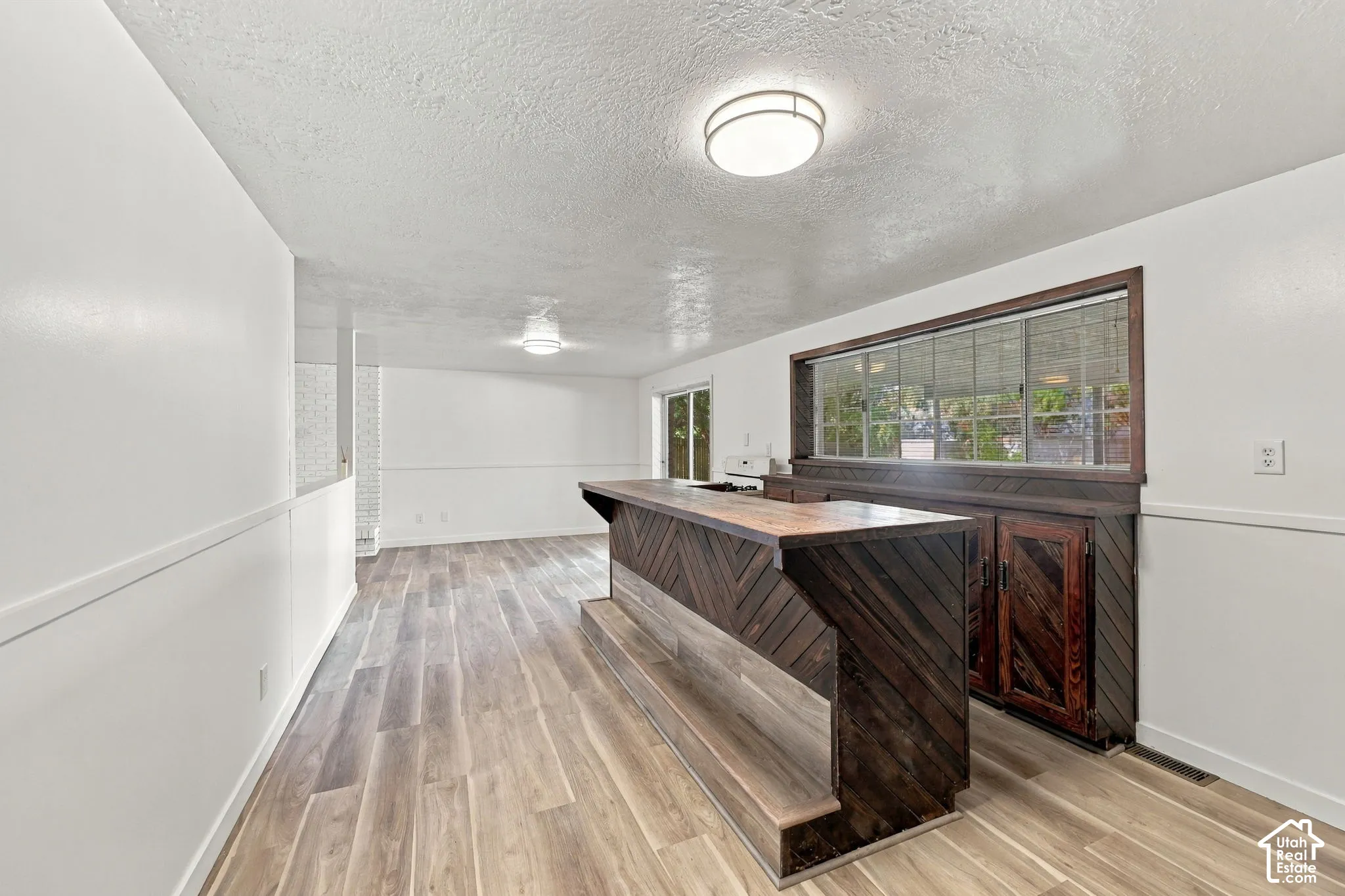 Custom built-in bar with wood-finish paneling, wood-finish countertop, and integrated storage cabinetry