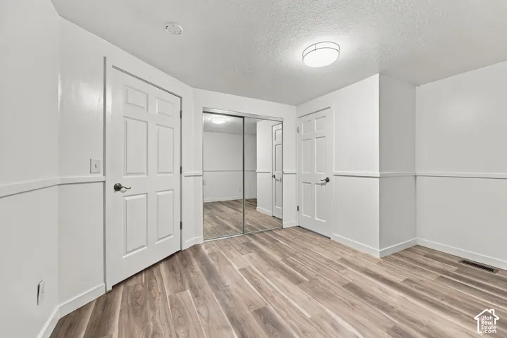 Wood-finish flooring, white panel doors, and a mirrored closet door