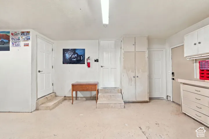2 car garage and exterior doors to the home along with storage space and tool bench