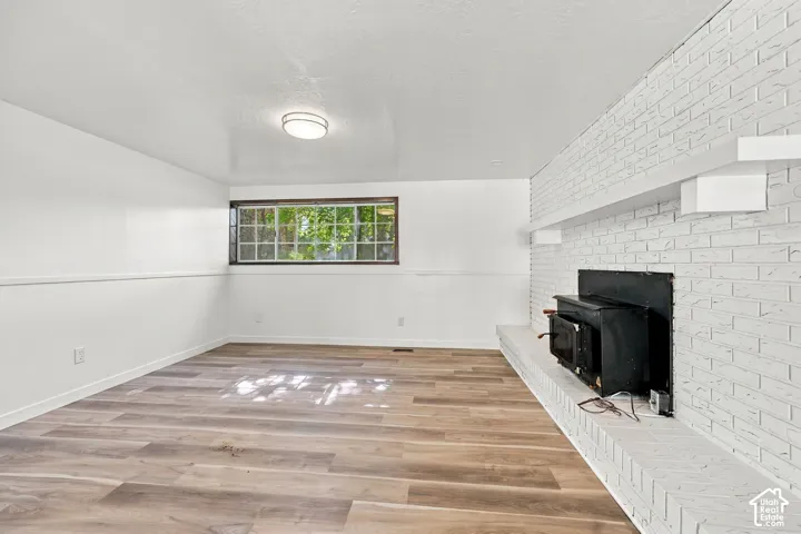 Wood-finish flooring, white painted walls, and a recessed window with grilles