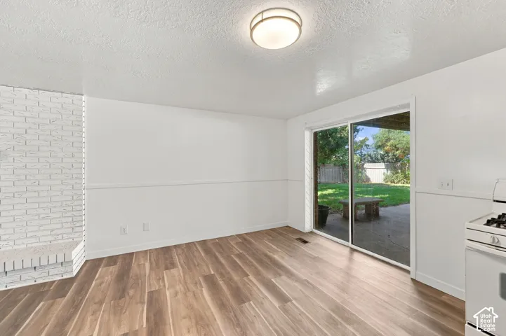 Wood-finish flooring with white wall finishes and a white brick fireplace