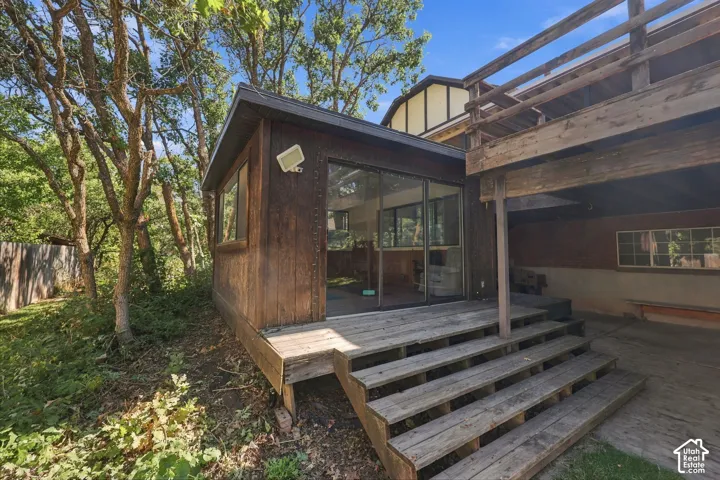 Wood-paneled exterior with multiple windows and sliding glass doors, leading to a multi-level wood deck