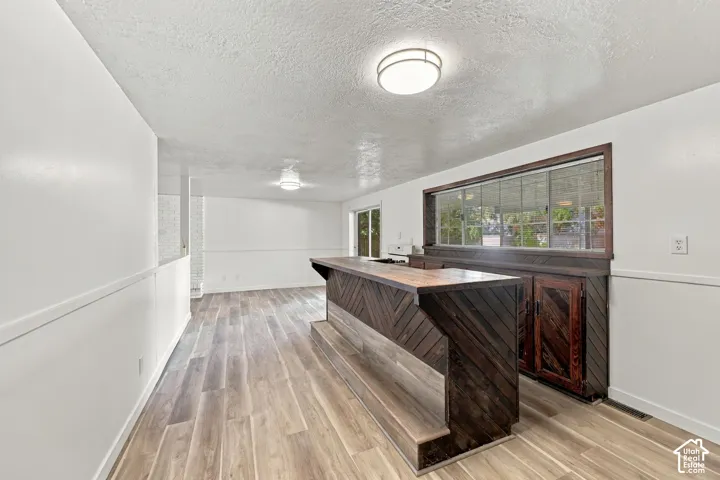 Custom built-in bar with wood-finish paneling, wood-finish countertop, and integrated storage cabinetry
