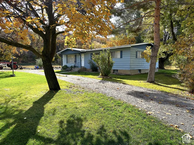 Light blue siding residence with a white front door and covered entry