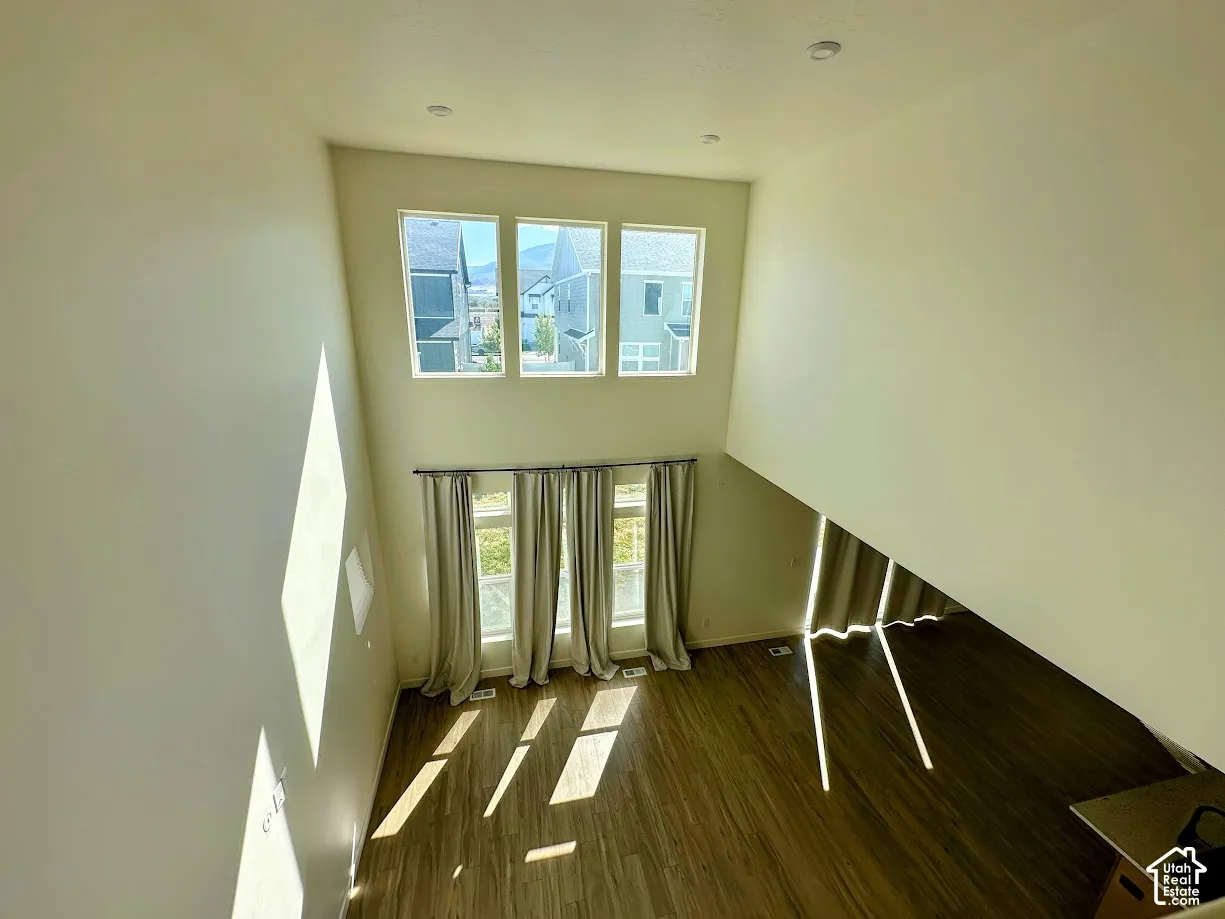 Expansive room with high ceilings and wood-finish flooring