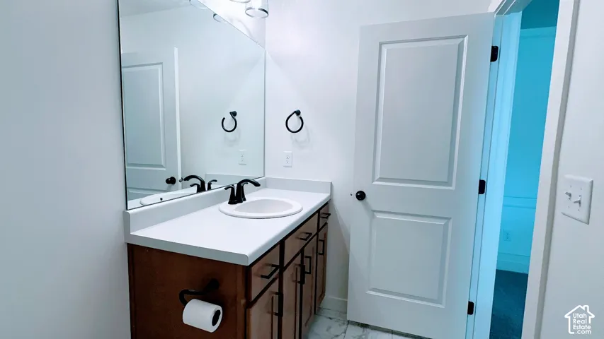 Bathroom vanity with an undermount sink, matte black faucet, and a large wall-mounted mirror