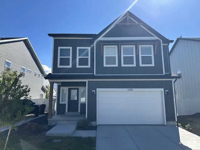 Two-story residence featuring a blue-gray exterior, an attached two-car garage, and a covered front entry
