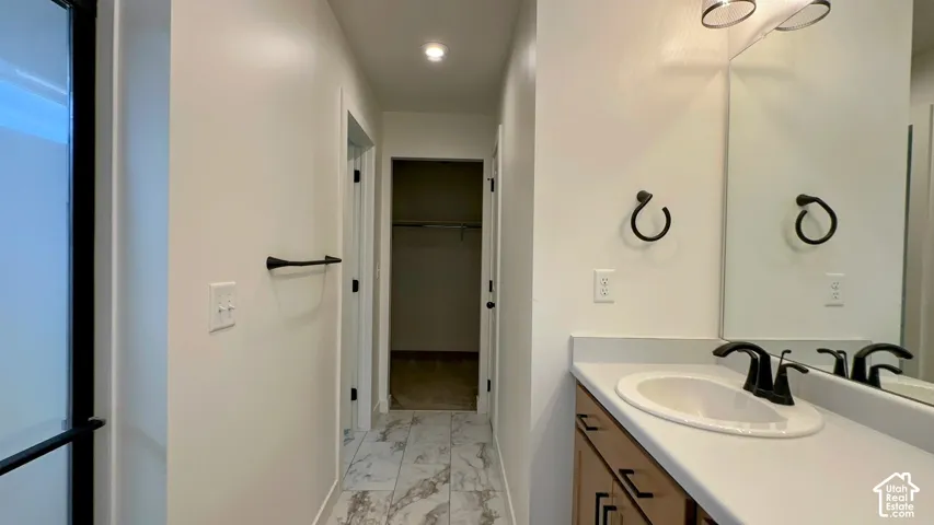 Vanity with integrated sink, black hardware, wall-mounted mirror, and overhead lighting