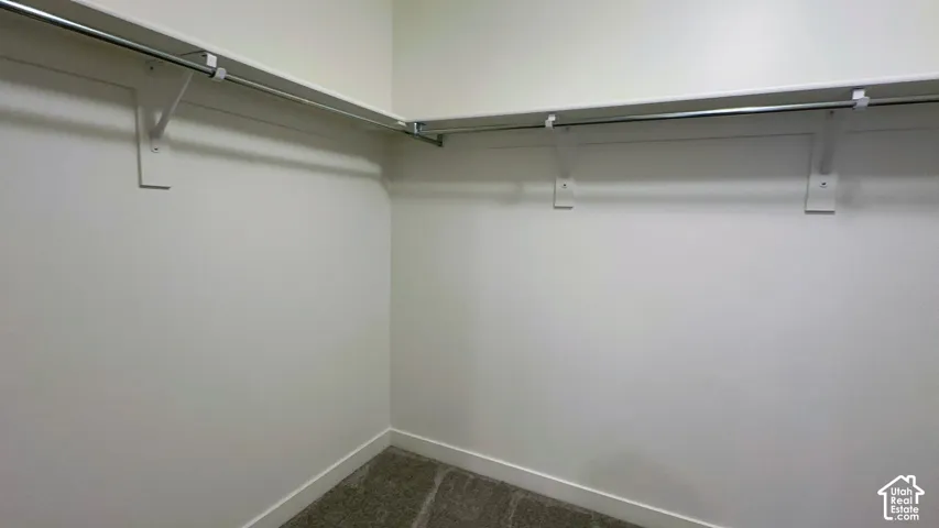 Corner closet with metal hanging rods and integrated shelving