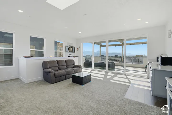 Recessed lighting, skylight, multiple windows, sliding glass door, and a spacious balcony