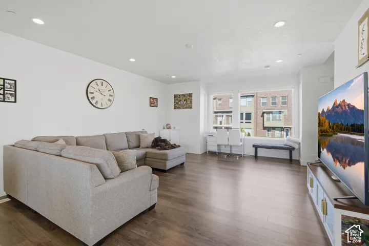 Wood-finish flooring, recessed lighting, and large windows with white trim