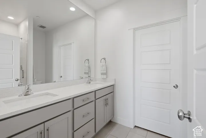 Double vanity with light gray cabinetry and brushed nickel hardware