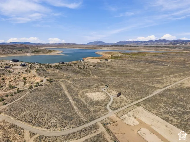 Expansive land offering a lake backdrop, distant mountains, and undeveloped terrain