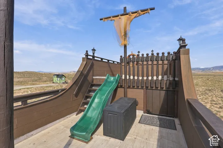 Custom-built play structure featuring a slide, stairs, and ship-themed railing