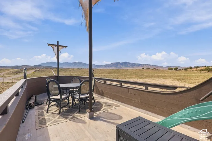 Expansive outdoor deck with wood-finish flooring, a decorative mast, and brown wall paneling