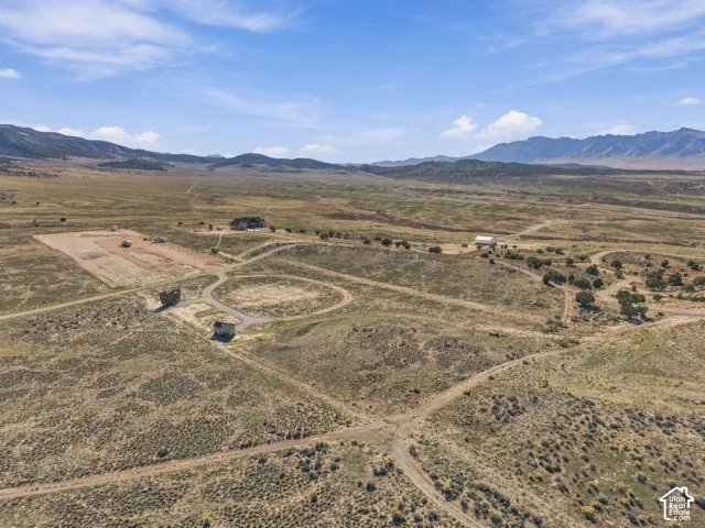 Expansive land featuring a developed building pad, established winding pathways, and scattered mature trees