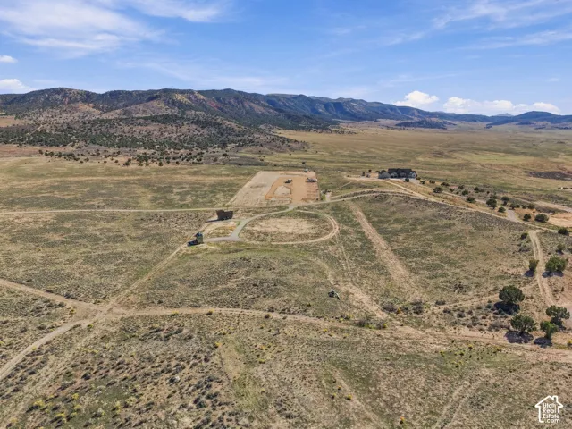 Expansive natural landscape with rolling hills, distant mountains, and a clear sky