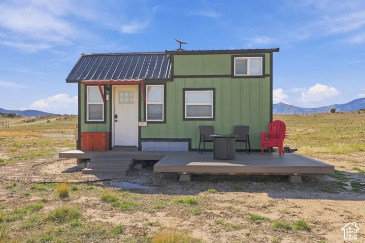 Compact structure with a durable metal roof, green vertical siding, and a white entry door