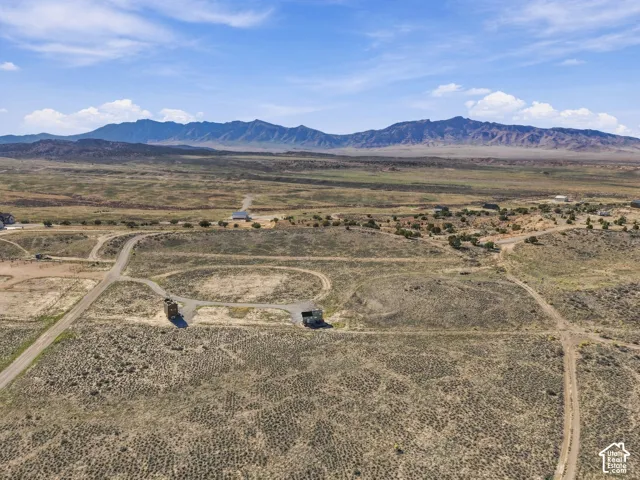 Expansive undeveloped land with a mountain backdrop, featuring a natural landscape and unpaved roads