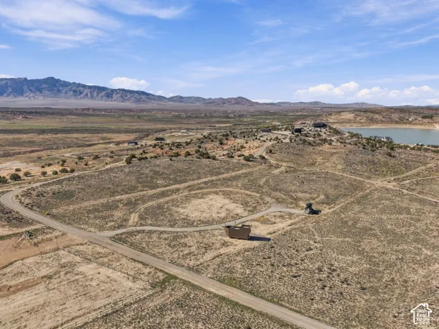 Expansive arid landscape featuring distant mountains and a body of water