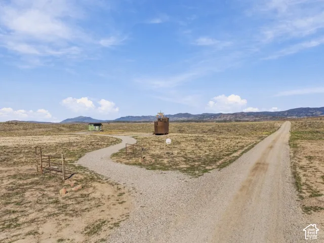 Gravel driveway and winding gravel path with distant structures