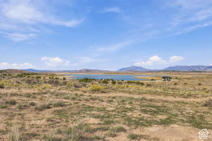 Expansive land with distant water body and mountainous backdrop