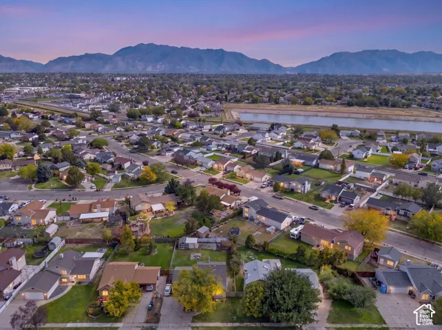 Suburban residential area with established homes, tree-lined streets, and distant mountain scenery