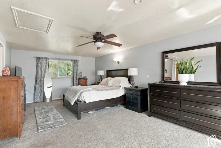 Carpeted flooring, ceiling fan with integrated lighting, wall sconces, window with blinds, and light-colored wall paint