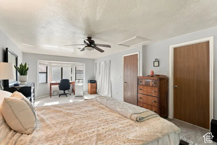 Bay window with blinds, ceiling fan, and light-toned wall paint
