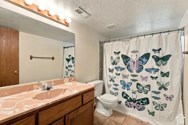 Vanity with integrated sink, wood-finish cabinetry, and overhead bar lighting