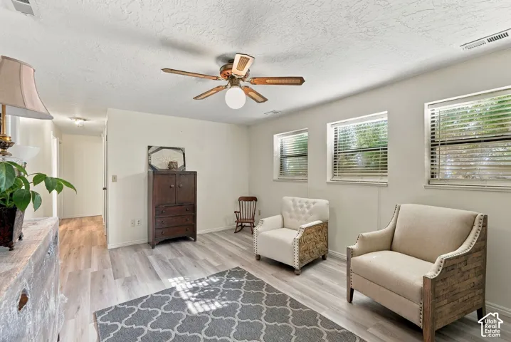 Wood-finish flooring with a ceiling fan overhead