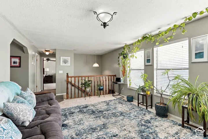 Recessed lighting, wood railing, and multiple windows with blinds