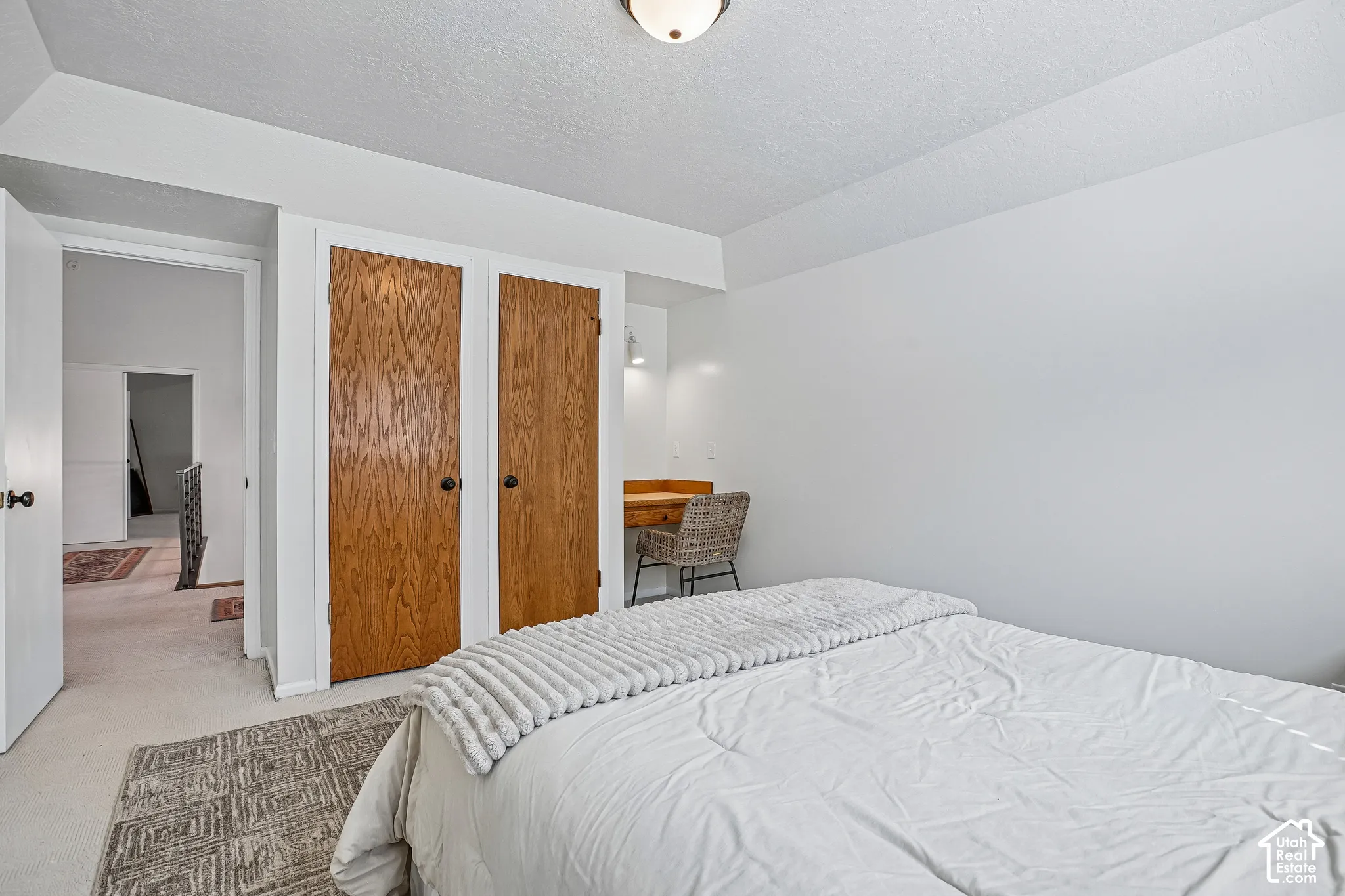 White walls throughout, wood-finish bi-fold closet doors, and recessed built-in desk area