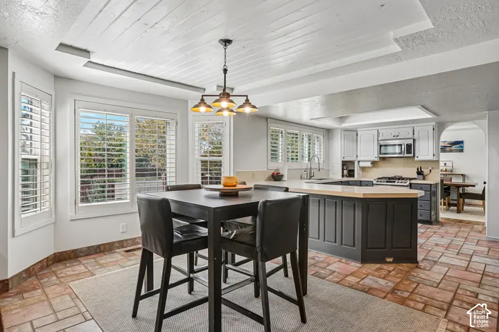 Kitchen featuring an island with wood-finish countertop, stainless steel appliances, and a gas range
